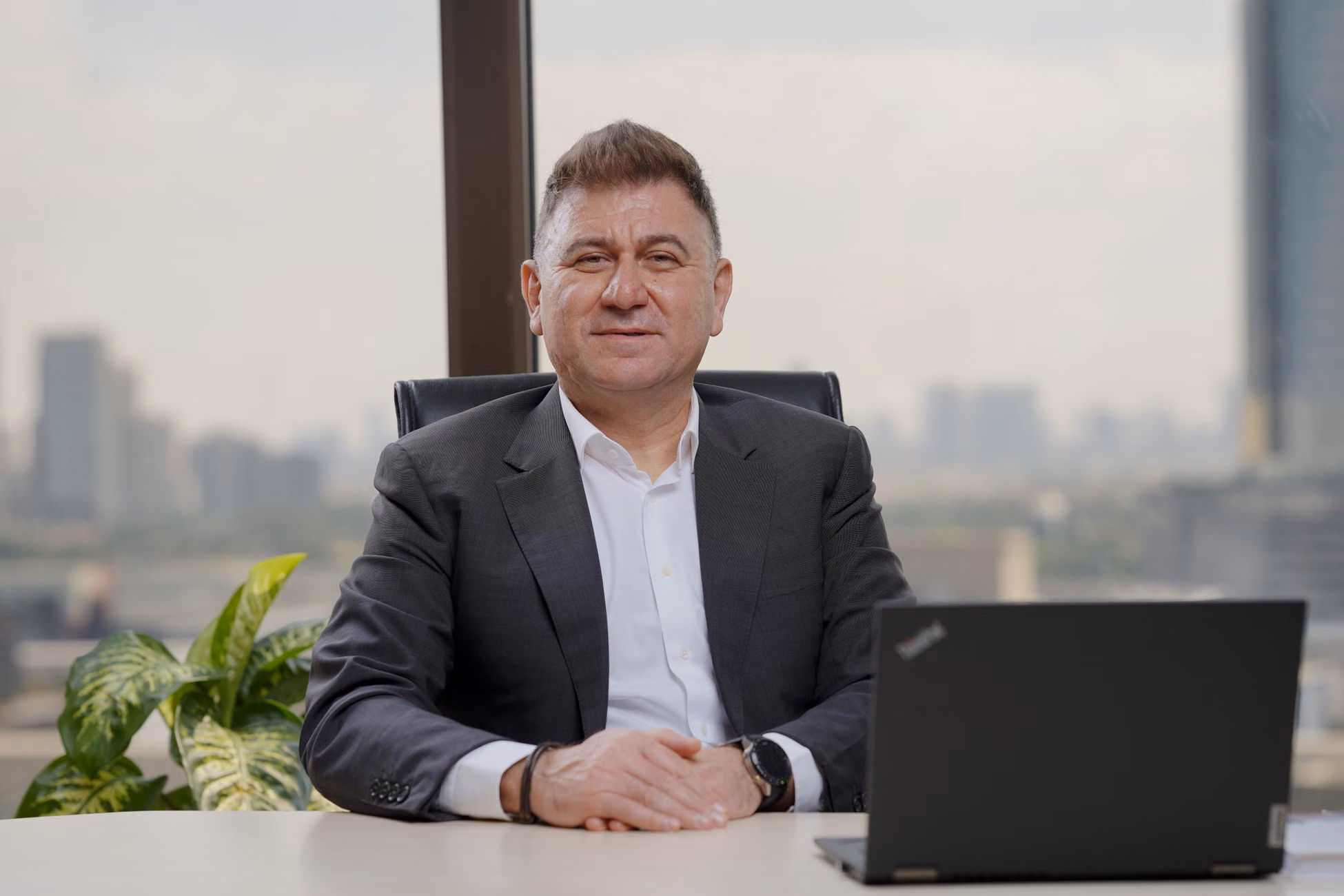 Confident middle-aged businessman in an elegant office with city view.