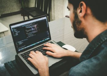 man programming using laptop