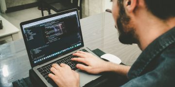 man programming using laptop