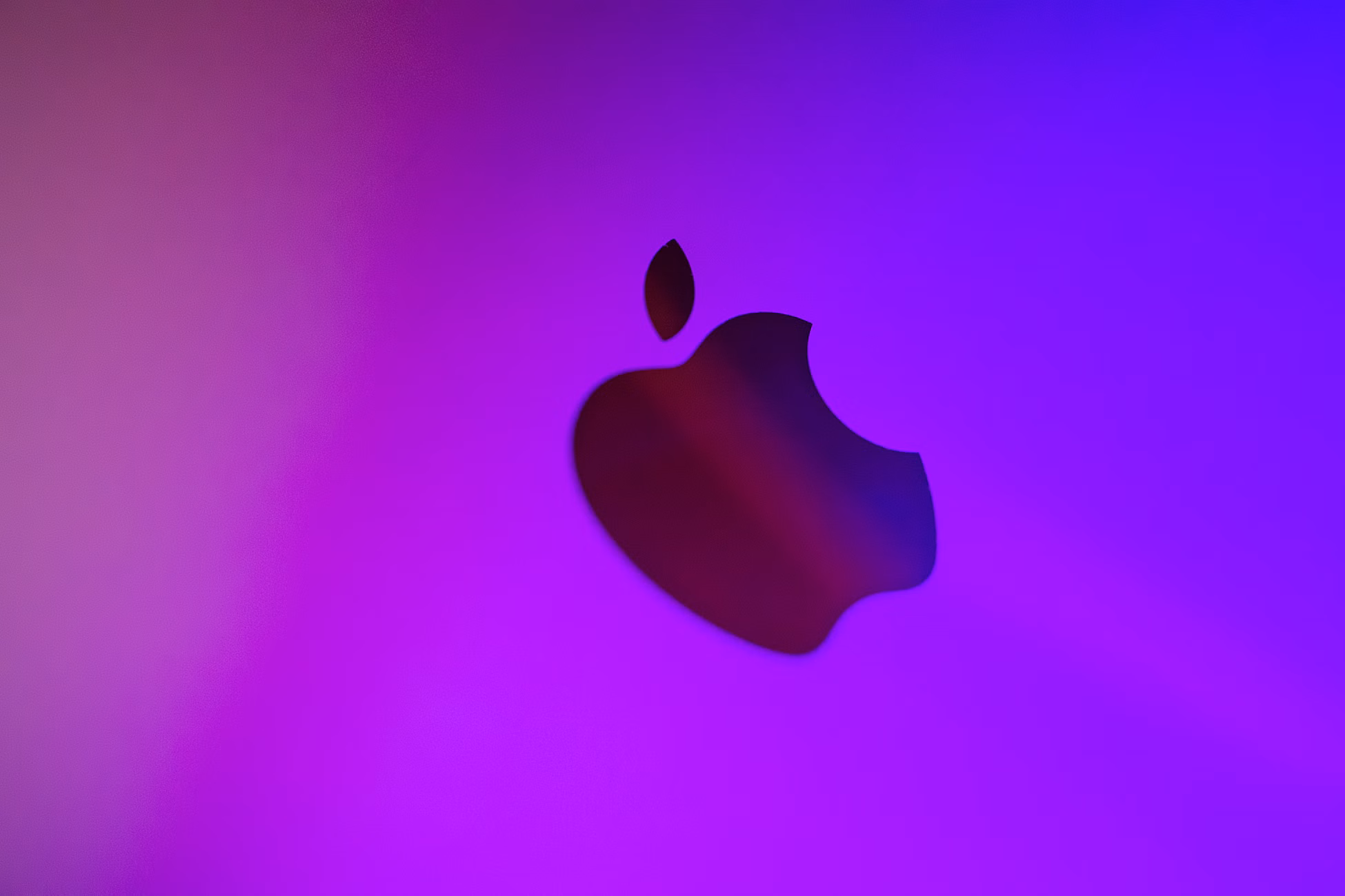 A vibrant abstract image featuring a silhouette of an apple against a purple background.