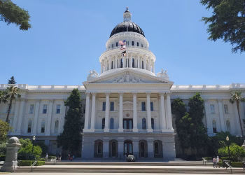 Front view of Sacramento's California State Capitol with clear blue sky.