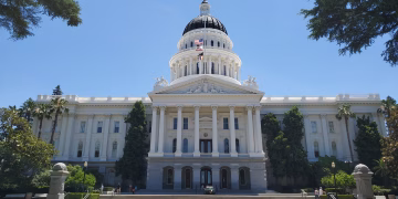 Front view of Sacramento's California State Capitol with clear blue sky.