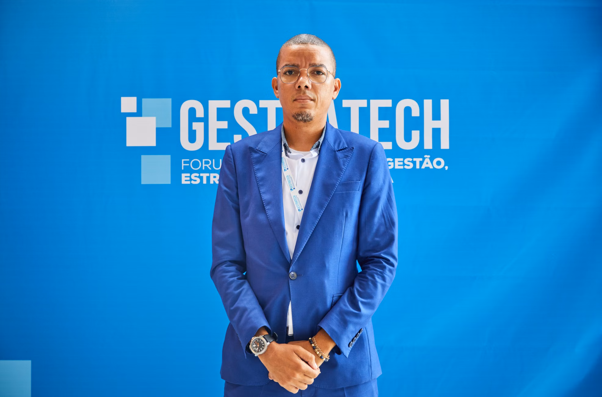 Confident businessman in blue suit at a professional conference event.