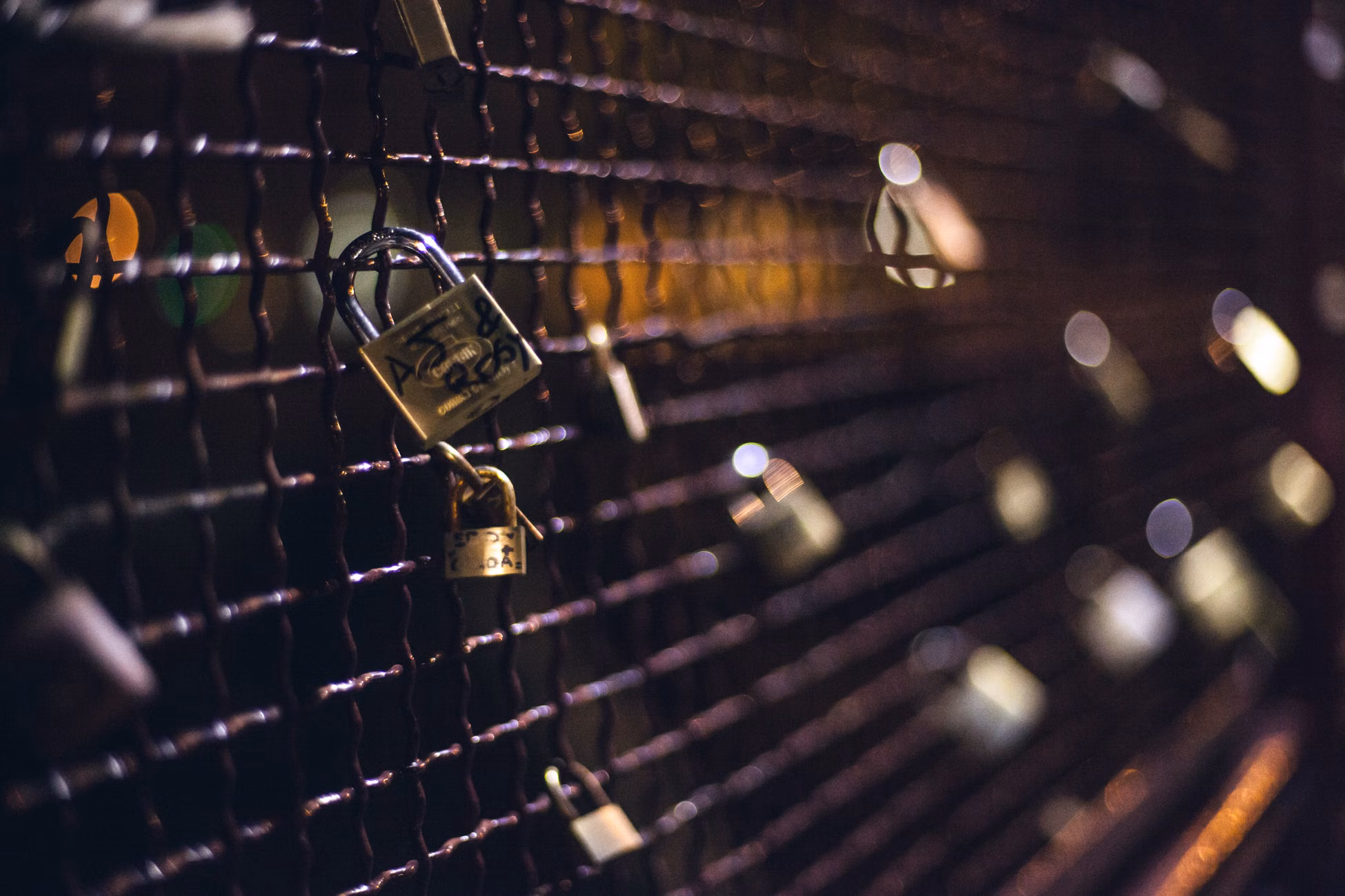 A chain-link fence adorned with numerous padlocks symbolizing love and commitment.