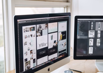 Modern office desk setup with dual monitors displaying design software, ideal for tech and business themes.