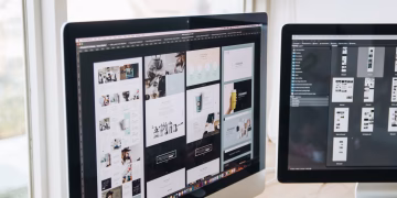 Modern office desk setup with dual monitors displaying design software, ideal for tech and business themes.