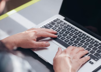 Focused view of a person typing on a laptop, showcasing productivity and technology.