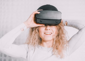 Smiling woman wearing a VR headset and experiencing virtual reality excitement.