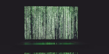 Abstract depiction of green matrix code on a computer monitor.