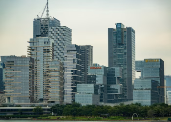 Skyline featuring modern skyscrapers with prominent logos of major companies.