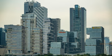 Skyline featuring modern skyscrapers with prominent logos of major companies.