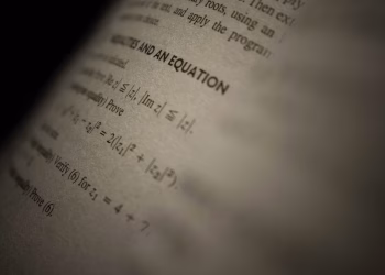 Selective focus on a mathematics textbook page with complex equations and text.