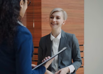 Two professionals having a conversation during a business meeting indoors.