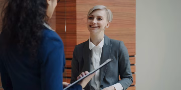 Two professionals having a conversation during a business meeting indoors.