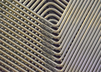 Detailed abstract view of stacked metal chair frames with a geometric pattern.