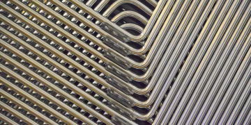 Detailed abstract view of stacked metal chair frames with a geometric pattern.