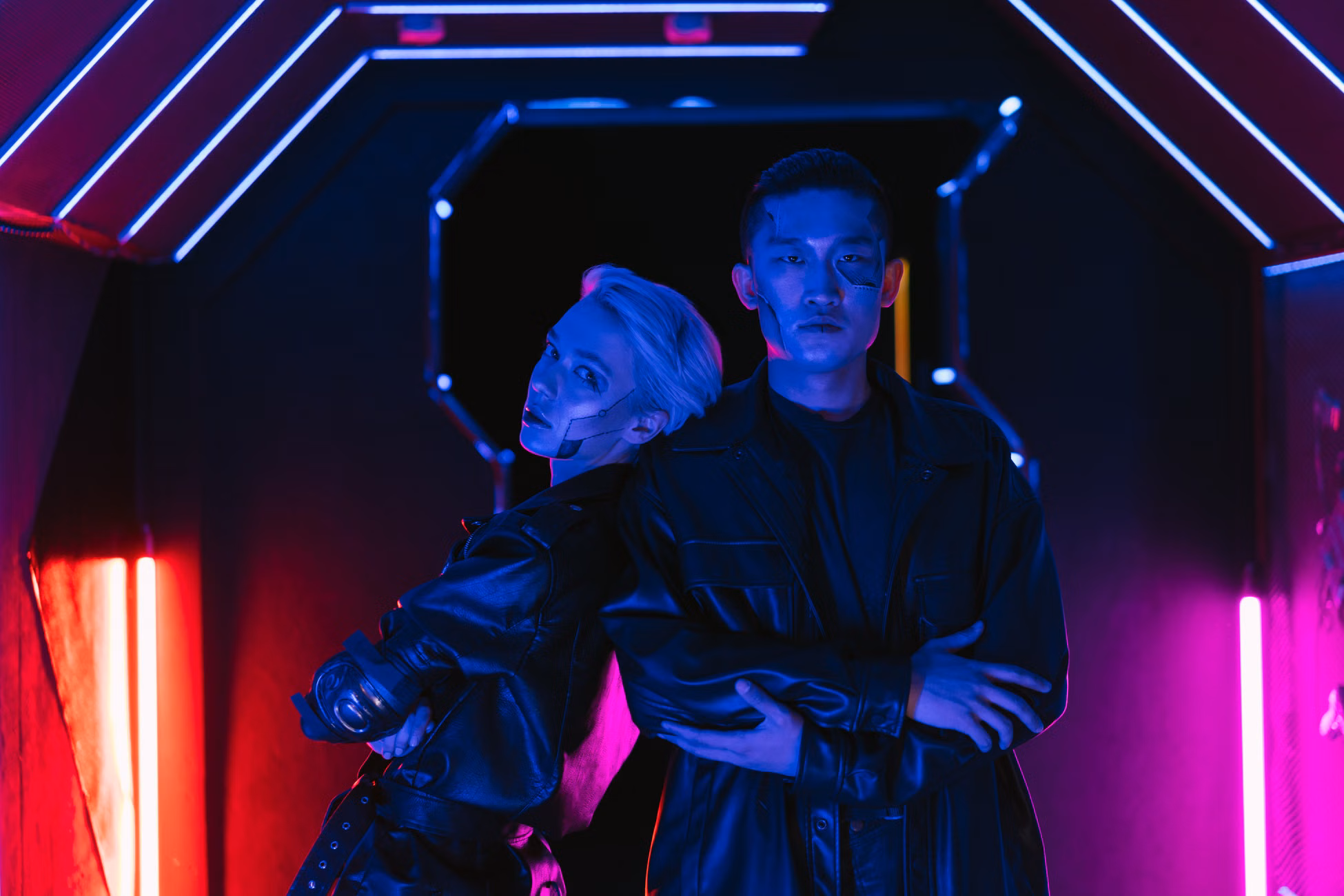 Two stylish individuals in a cyberpunk setting embracing futuristic fashion under neon lights.