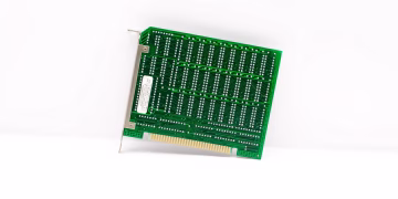 Retro green circuit board with connectors, representing early computer technology.