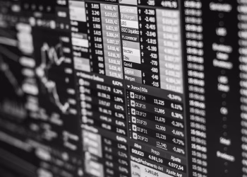 Monochrome image of stock market data on a screen, depicting financial information and trends.
