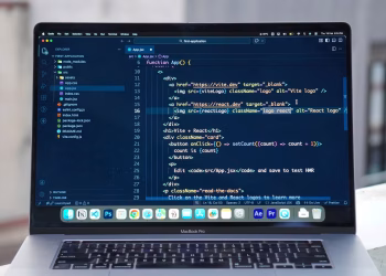 A MacBook Pro displaying code editor on a rooftop setting in daylight, ideal for a remote work lifestyle.