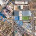 A stunning overhead shot of a sports complex with tennis courts, football field, and nearby park facilities.