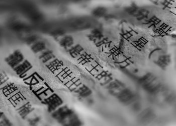 Artistic close-up of Chinese text on crumpled paper with selective focus and blur.