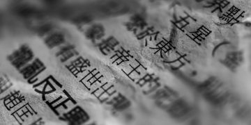 Artistic close-up of Chinese text on crumpled paper with selective focus and blur.