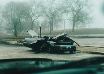 A foggy morning with a severely damaged car on a deserted street in Chicago.