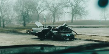 A foggy morning with a severely damaged car on a deserted street in Chicago.