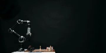 An articulated robotic arm competes in chess on a board against a dark background, highlighting AI and innovation.