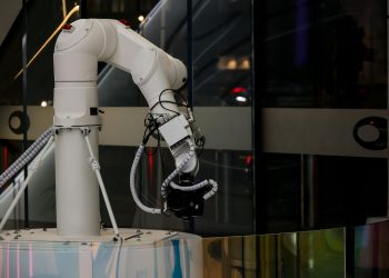 A white robotic arm operating indoors with a modern design and advanced technology.