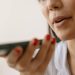 Close-up of a woman using smartphone voice command, showcasing technology and communication.
