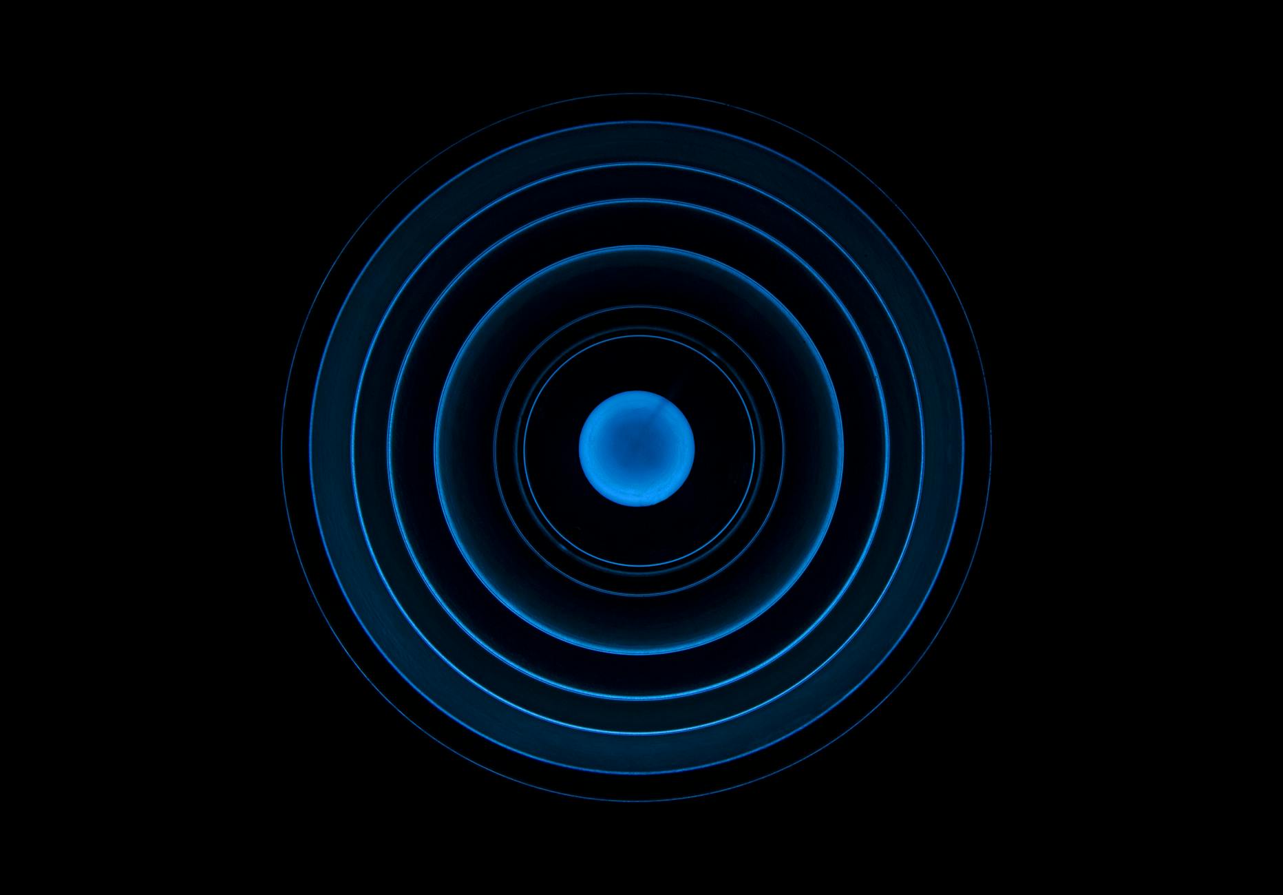 Abstract blue concentric circle pattern on a black background, ideal for futuristic designs.