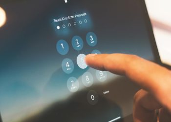 Close-up of a finger entering a passcode on a smartphone security screen.