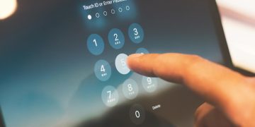 Close-up of a finger entering a passcode on a smartphone security screen.