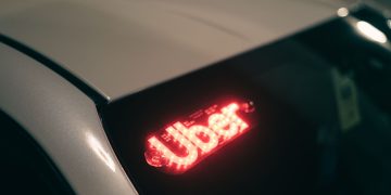 Close-up of a ride-sharing car with a bright red illuminated sign for night-time travel.