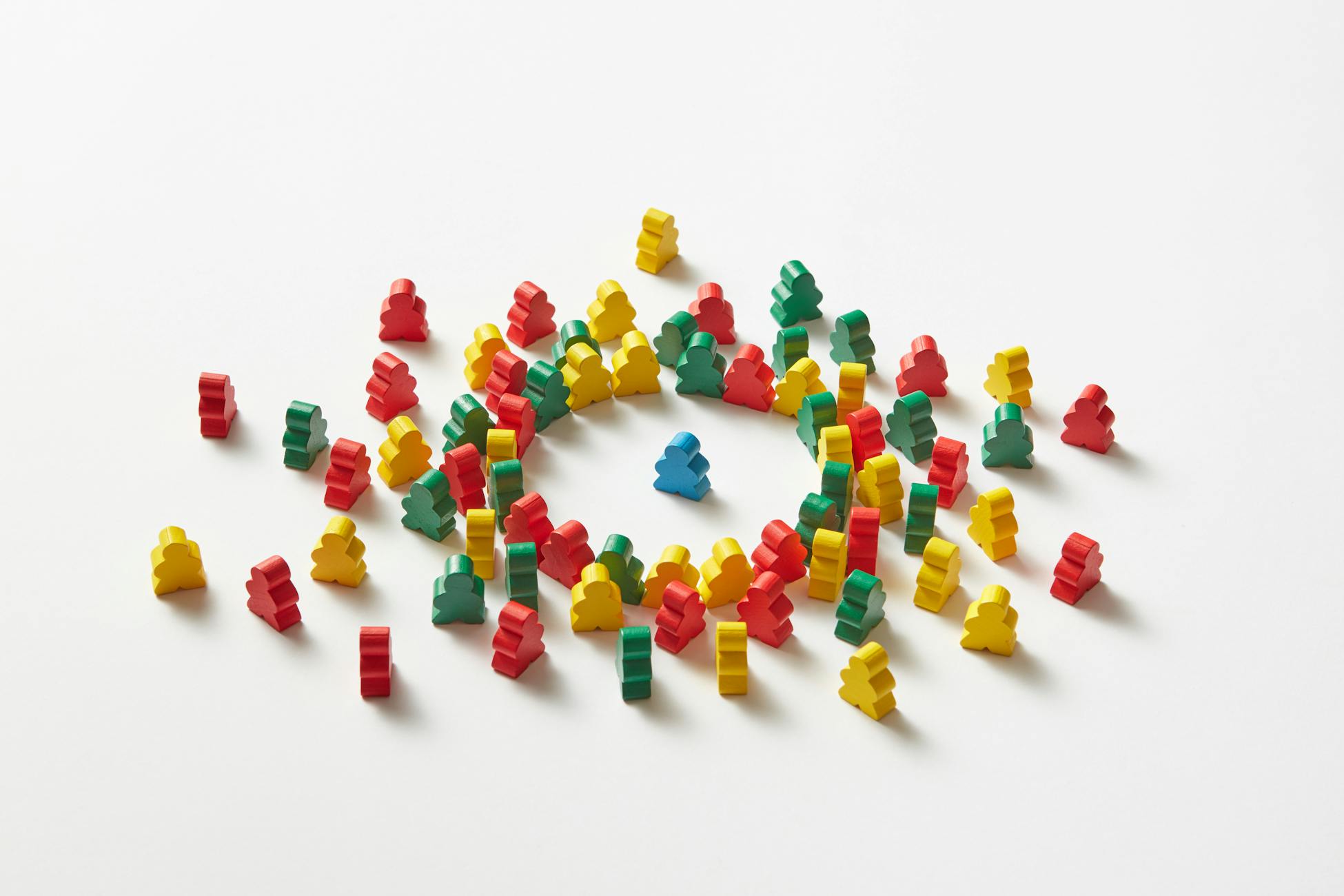 Vibrant wooden figures scattered and forming a circle on white background.