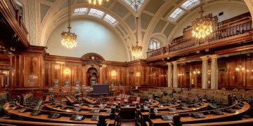 A beautifully designed chamber room with ornate woodwork and chandeliers in the UK.