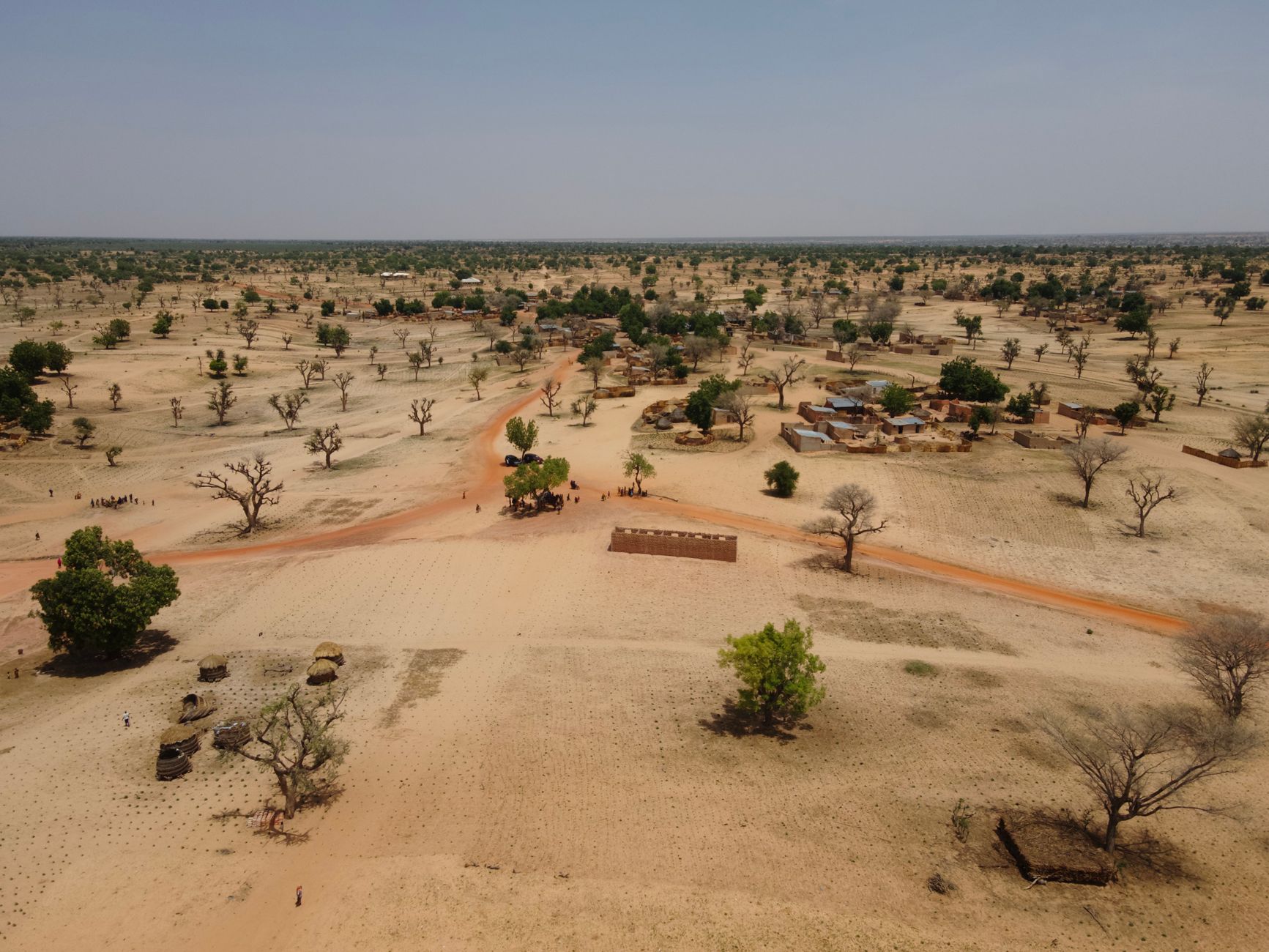 Aerial view of a dry rural landscape with sparse vegetation and scattered homes.