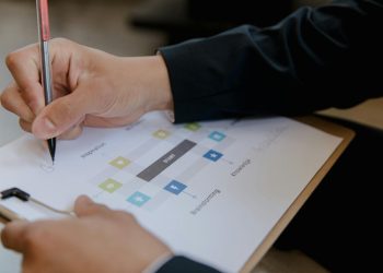 Close-up of a person writing on a business strategy document with a pen.