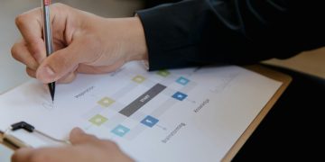 Close-up of a person writing on a business strategy document with a pen.