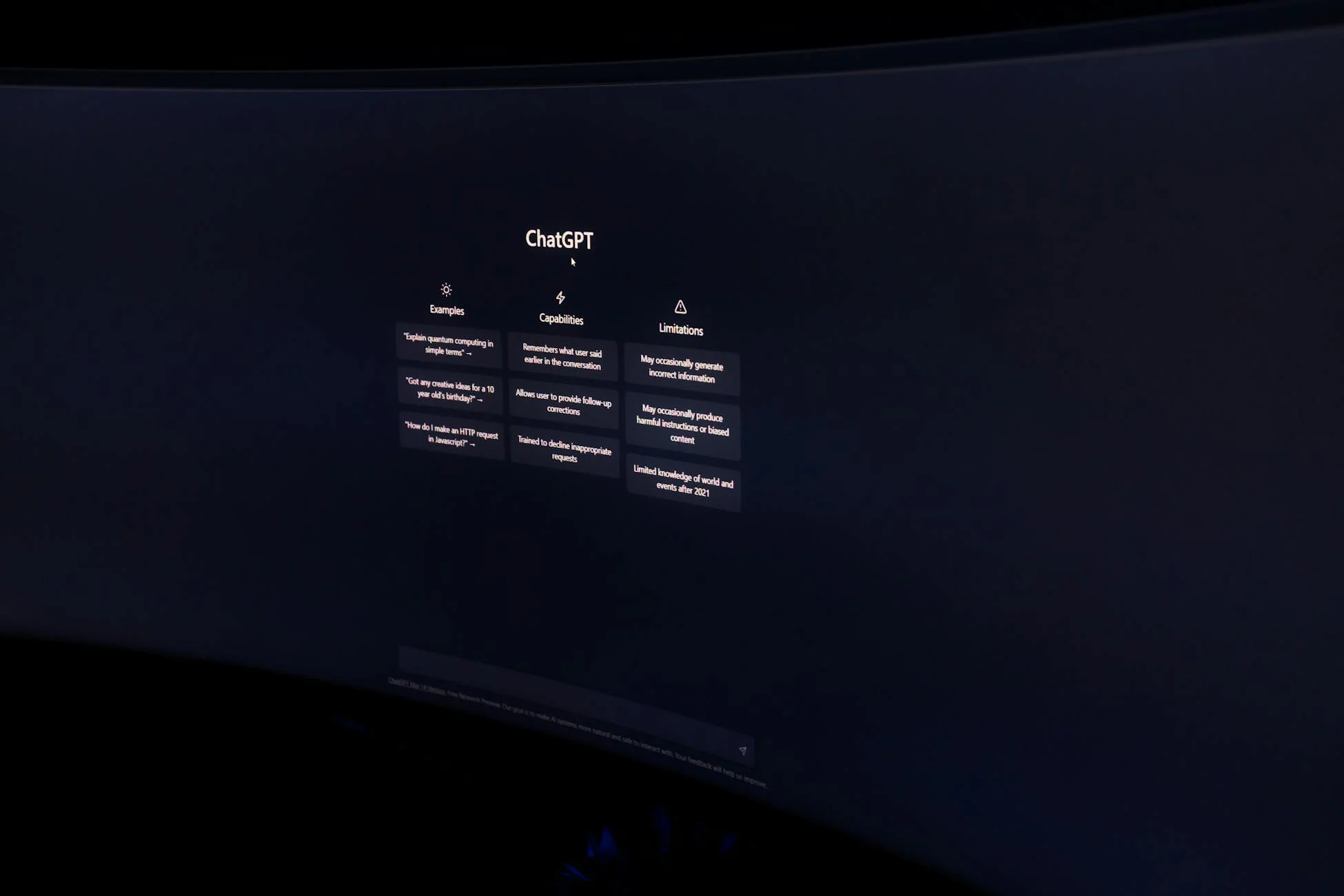 A dark, minimalist photo of a computer monitor displaying the ChatGPT interface.
