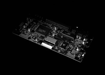 Detailed black and white image of a computer circuit board, showcasing technology components.