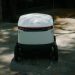 Autonomous delivery robot in urban setting, showcasing modern technology.