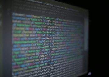 Close-up of colorful programming code on a blurred computer monitor.