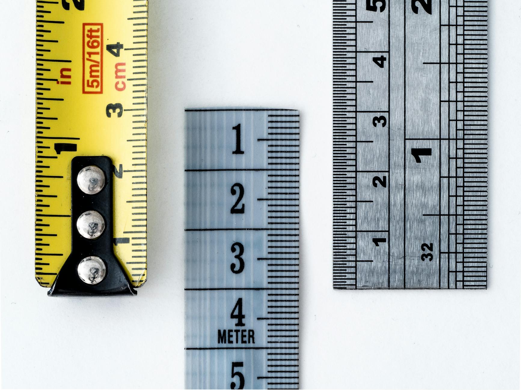 High-resolution image of a tape measure and rulers, showing precise millimeter, centimeter, and inch markings.