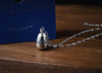Detailed close-up of a unique necklace with a timer pendant on a wooden surface, ideal for mechanical fashion lovers.