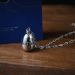 Detailed close-up of a unique necklace with a timer pendant on a wooden surface, ideal for mechanical fashion lovers.