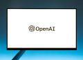 Minimalistic display of OpenAI logo on a monitor with a gradient blue background, representing modern technology.