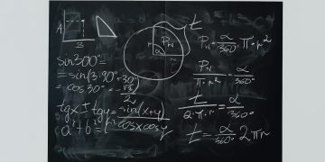 Detailed view of mathematical equations and diagrams on a blackboard.